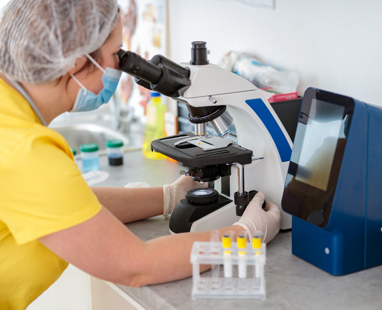 Staff member reviewing microscope